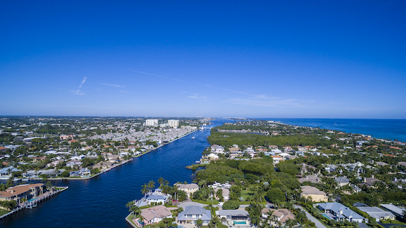 A bird’s eye view of Delray Beach, FL on a sunny day showcasing the waterways and neighborhoods.