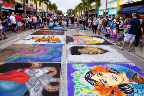 Sidewalk chalk painted onto the streets of Lake Worth, Florida, surrounded by crowds of people admiring the work.